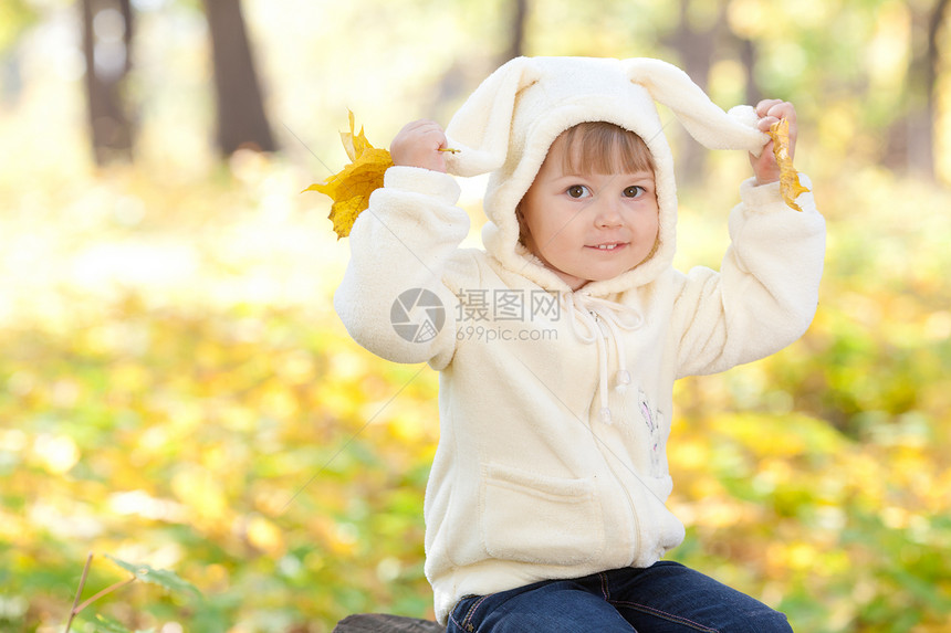 秋天森林中穿着装扮小兔子的漂亮女孩女性季节女孩微笑橙子公园快乐毛皮童年幸福图片