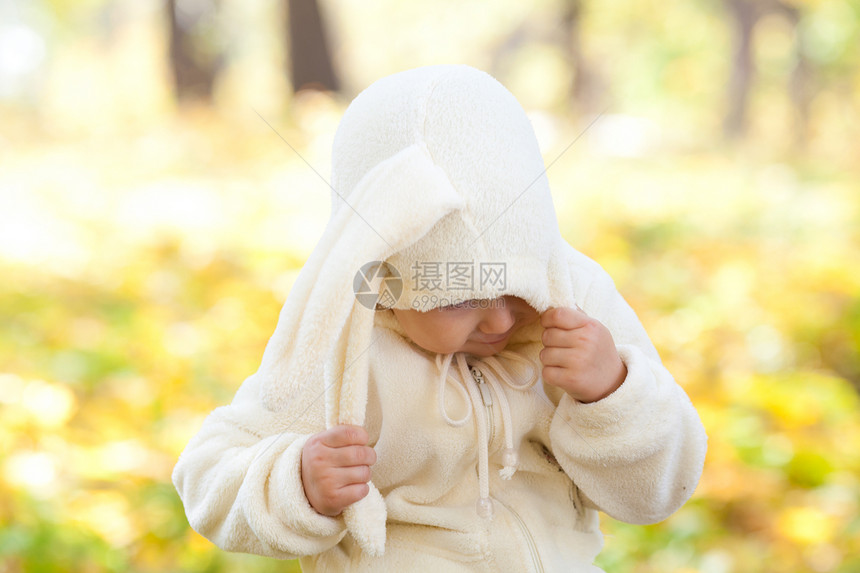 秋天森林中穿着装扮小兔子的漂亮女孩喜悦微笑童年快乐季节戏服橙子公园叶子女儿图片