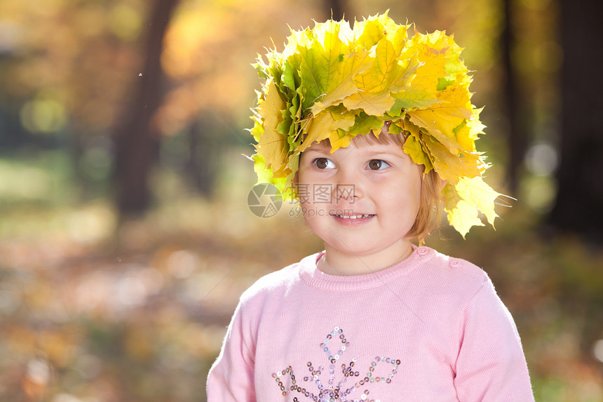 美丽的小女孩 在秋前秋叶的青树叶花圈中孩子童年快乐季节森林橙子女性乐趣叶子公园图片