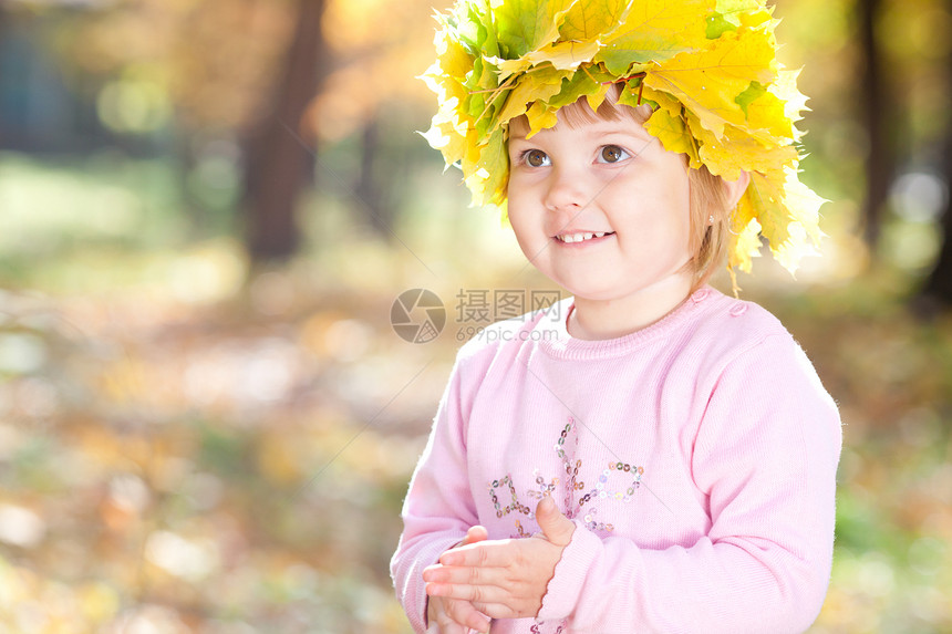 美丽的小女孩 在秋前秋叶的青树叶花圈中森林黄色橙子童年压痛喜悦乐趣季节公园微笑图片