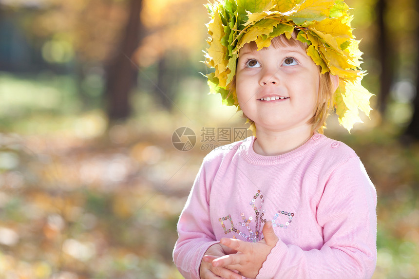 美丽的小女孩 在秋前秋叶的青树叶花圈中女孩童年季节公园森林微笑橙子压痛女儿女性图片