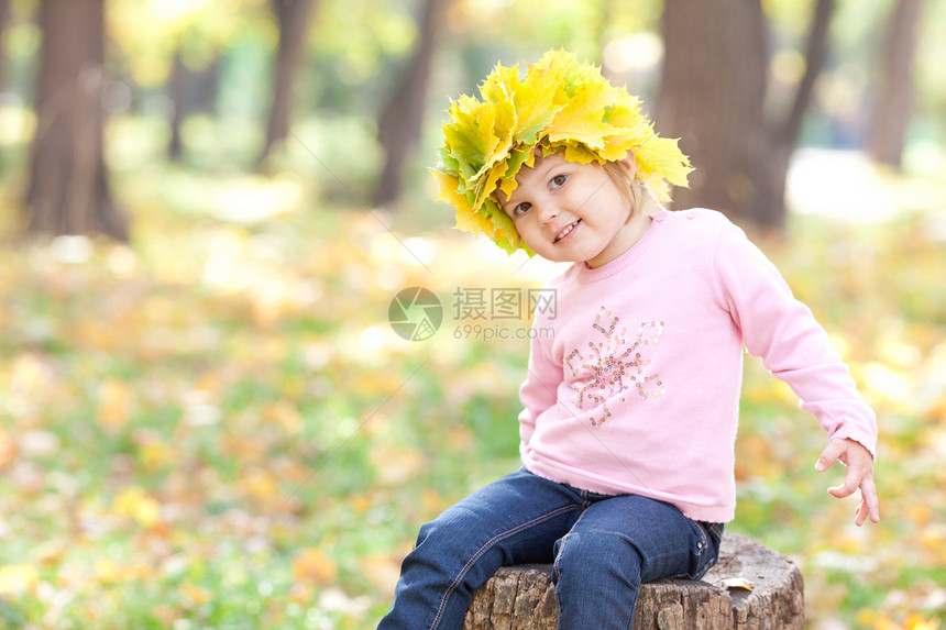 美丽的小女孩 在秋前秋叶的青树叶花圈中黄色幸福喜悦树桩孩子森林压痛叶子橙子微笑图片