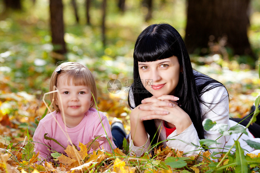 美丽的年轻母亲和女儿 躺在秋天的河里童年橙子森林孩子运动幸福季节快乐女士公园图片