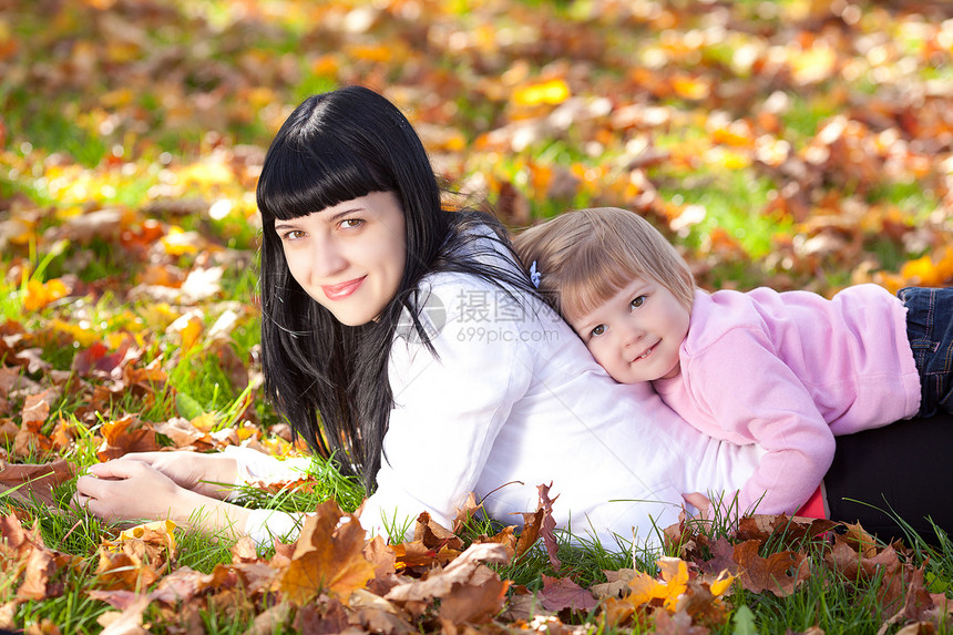 美丽的年轻母亲和女儿 躺在秋天的河里微笑童年父母季节快乐喜悦橙子女性幸福女士图片