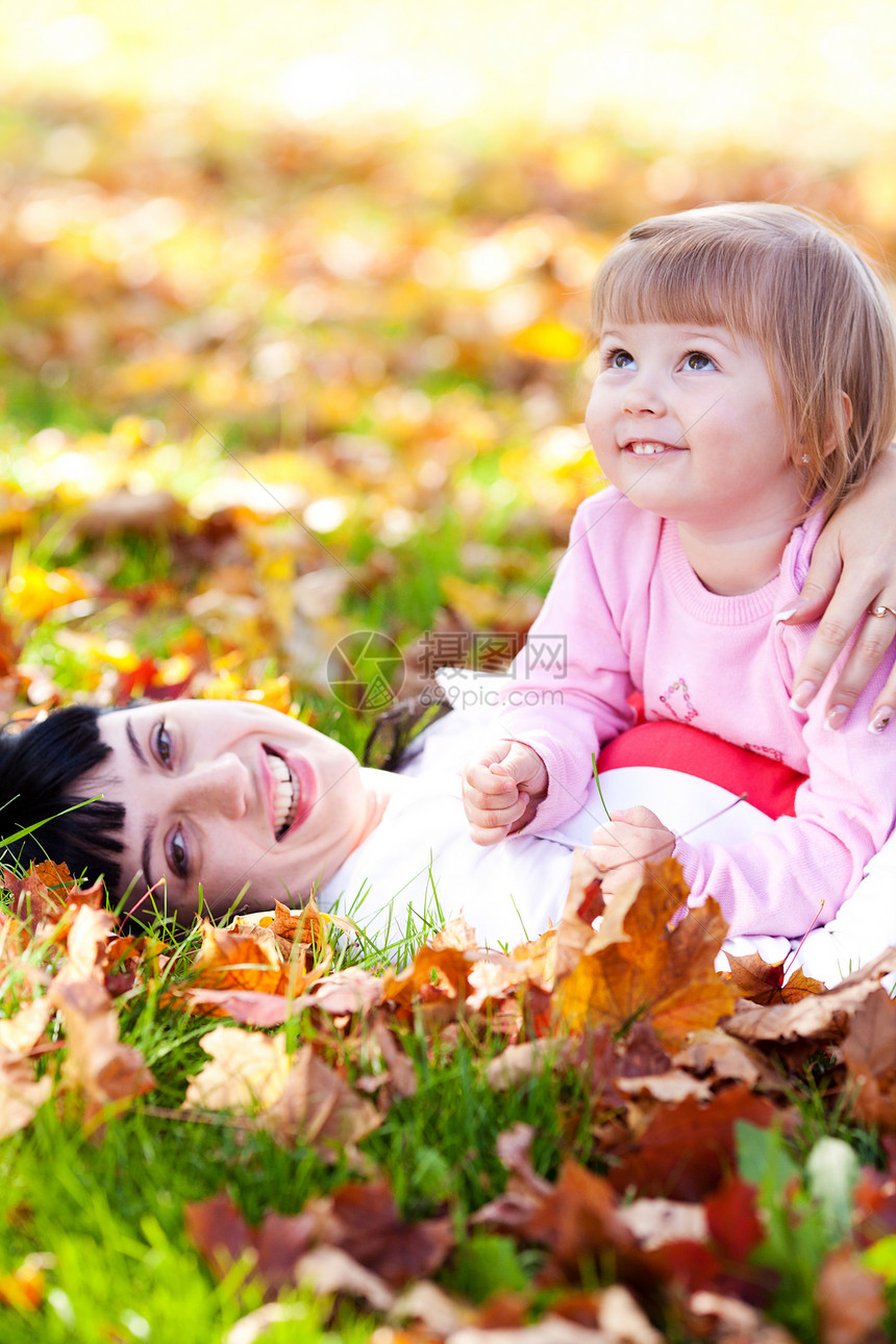 美丽的年轻母亲和女儿 躺在秋天的河里女士幸福乐趣微笑女性童年公园压痛父母拥抱图片