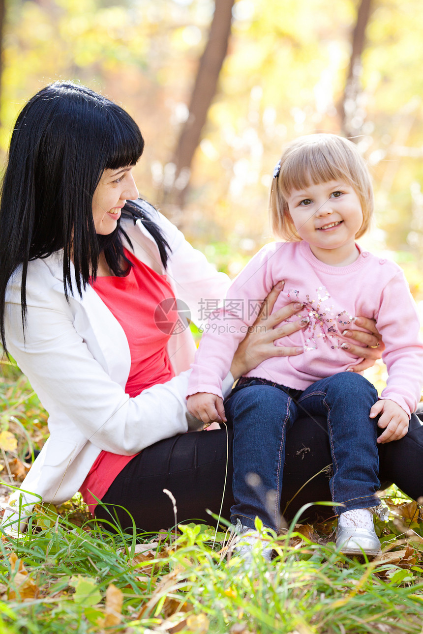 美丽的年轻母亲和女儿在自闭膜林中橙子女士父母童年女孩压痛乐趣森林幸福微笑图片