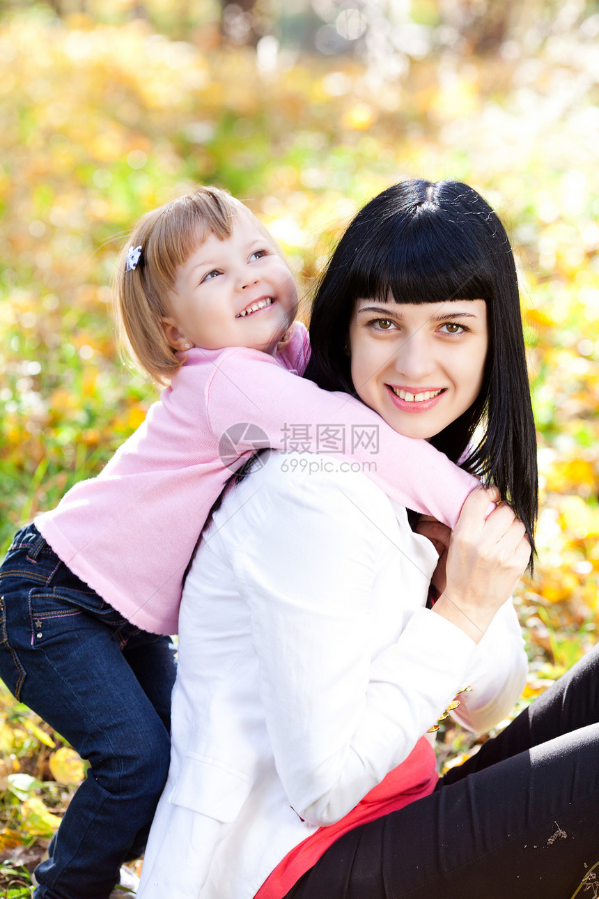 美丽的年轻母亲和女儿在自闭膜林中公园拥抱孩子橙子女性运动叶子喜悦快乐女士图片