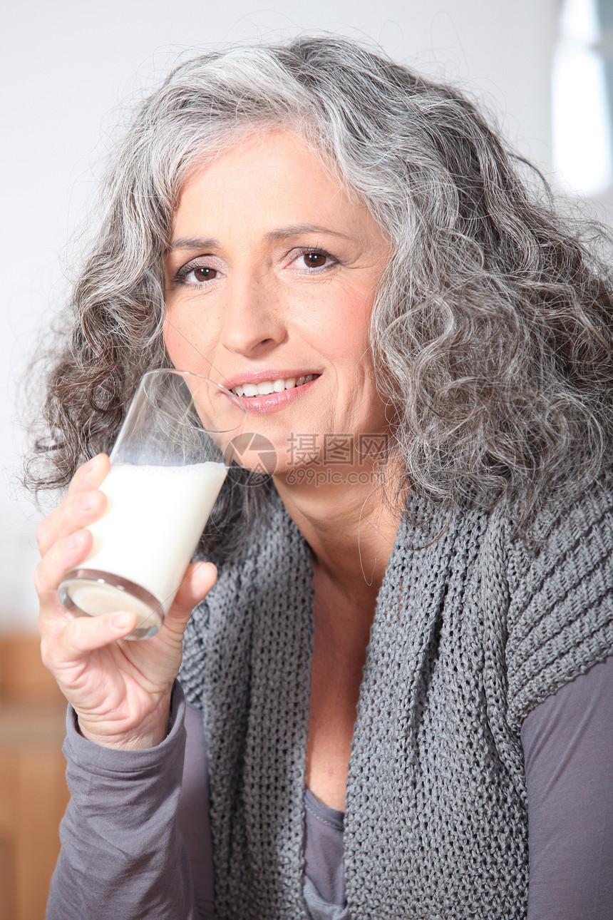 女人喝一杯牛奶骨头波浪状灰色胡椒头发奶牛女士玻璃饮料产品图片