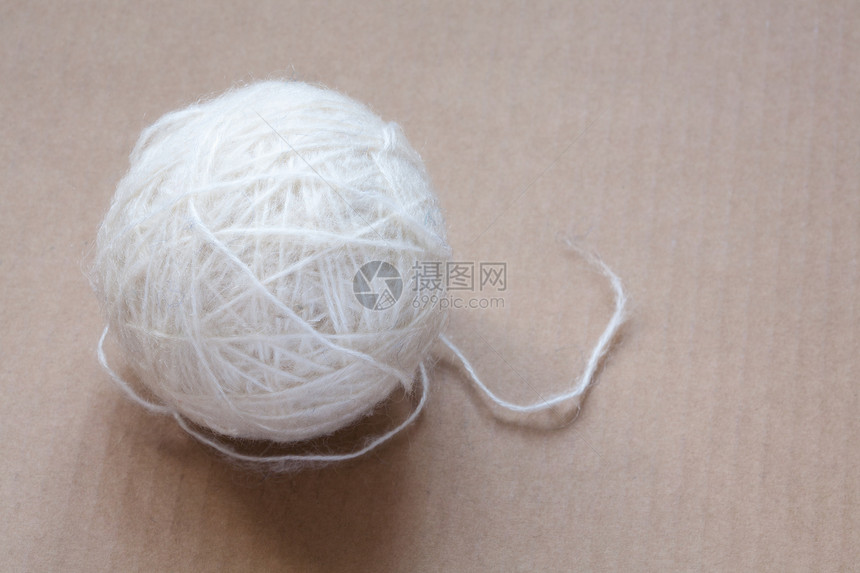 纸板背景上的白羊毛线球羊驼材料绳索旋转手工细绳纤维白色褐色加工图片