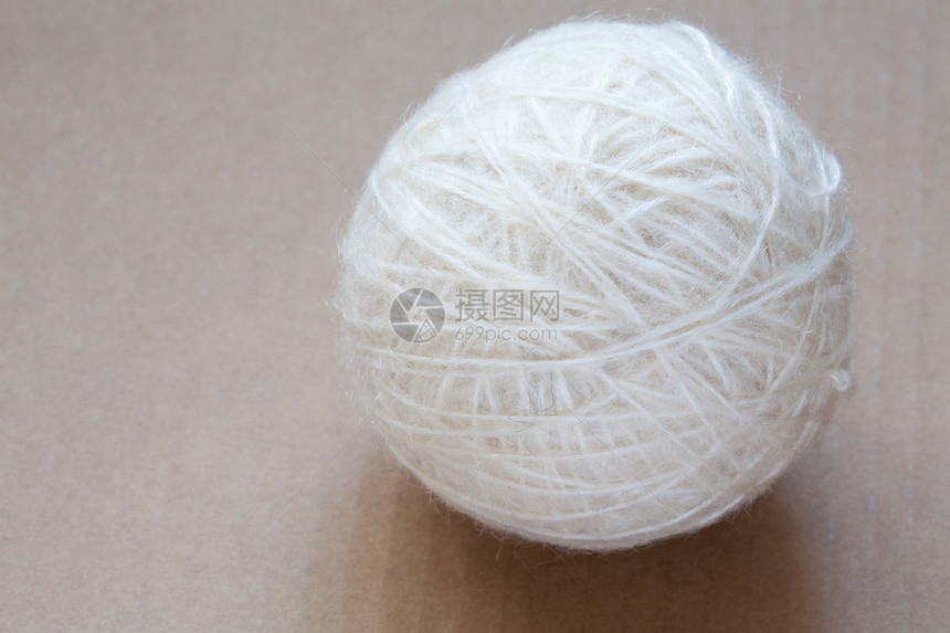 纸板背景上的白羊毛线球羊驼纤维纺织品爱好织物绳索旋转材料针线活褐色图片