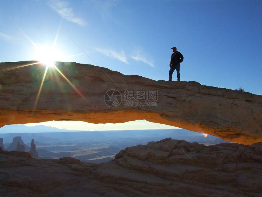 梅萨拱门 峡谷地国家公园 犹他州 美国侵蚀编队台面剪影红色坑洞岩石太阳男人远足图片