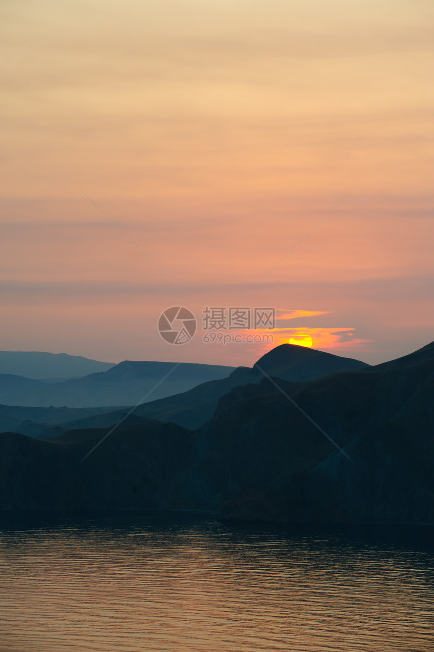 山岳和大海之间多彩的衰落悬崖日落异国旅行戏剧性海湾情调天空山脉海岸线图片