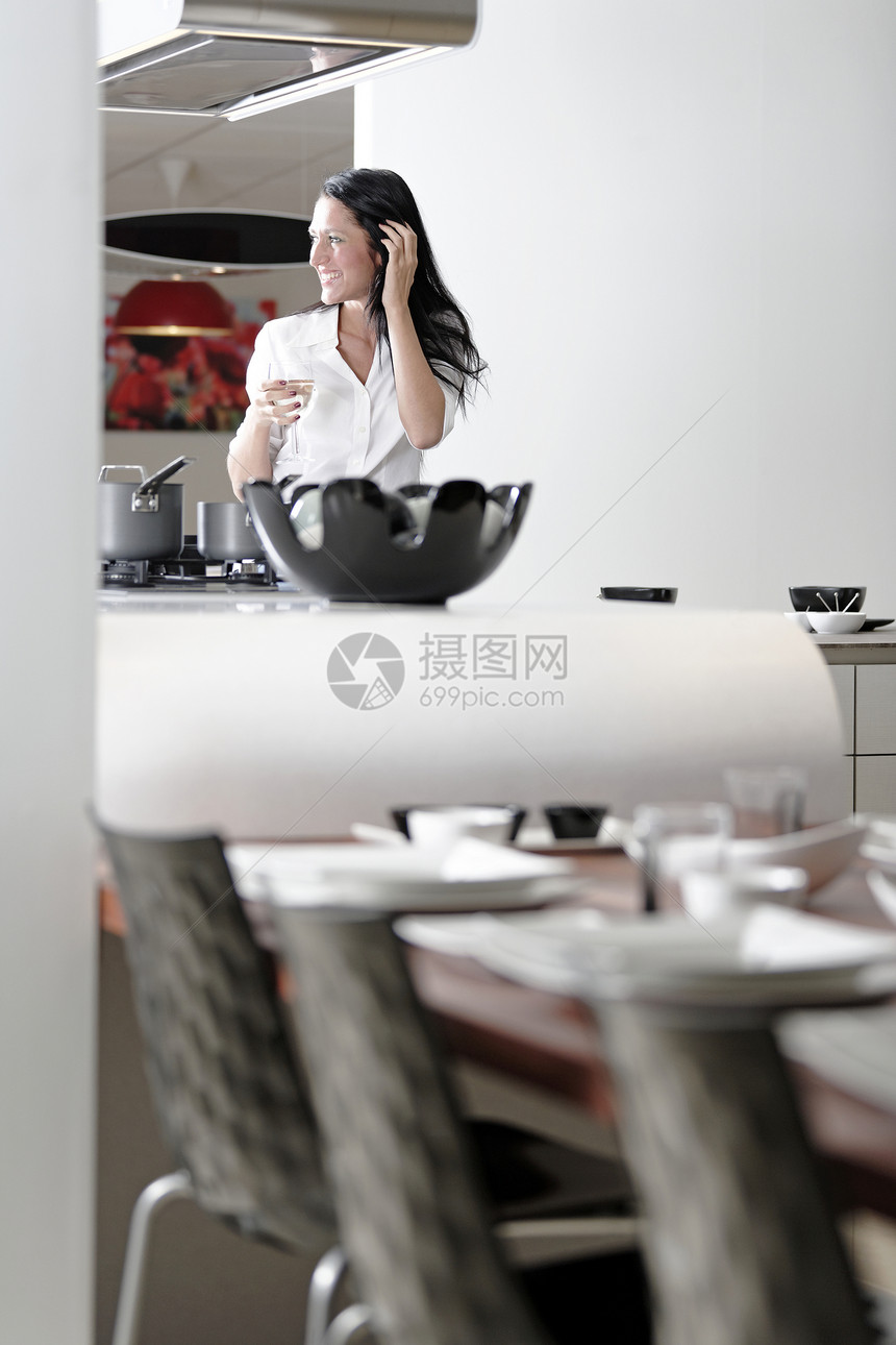 女人在她时尚的厨房设计师快乐女性派对女士女孩工作台面玻璃白色图片