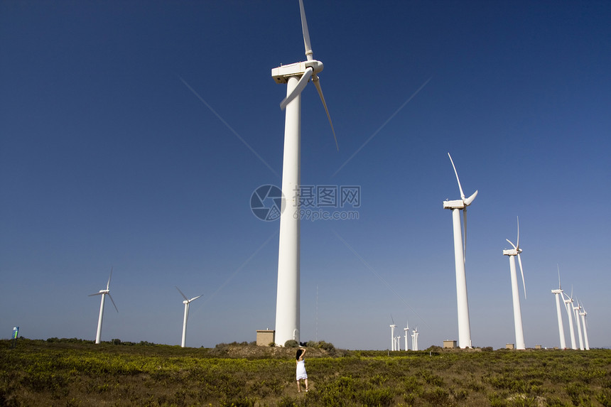女孩和风车涡轮生产技术女性蓝色电气白色生态创新发电机图片