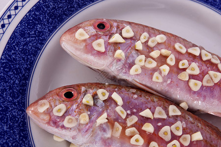 两条红鱼食物盘子营养红色白色背景图片