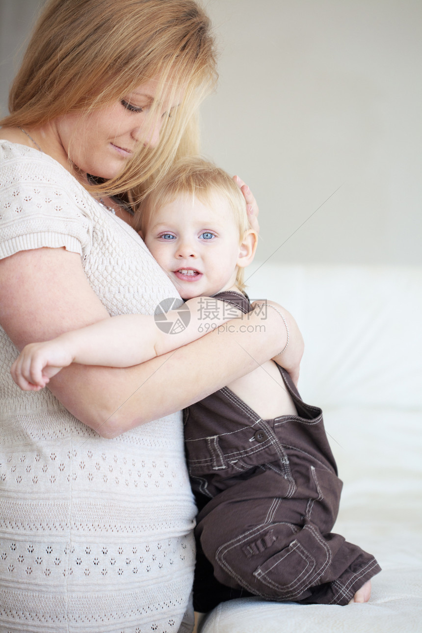 母亲及其子女父母婴儿幸福微笑女儿青年拥抱沙发快乐情怀图片