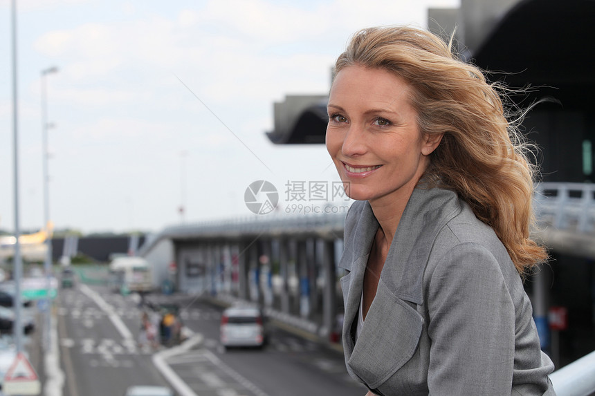 女商务人士笑着带着头发的风商业飞机场女性旅行导演微笑白色工作经理女士图片