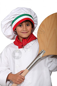 小男孩穿着披萨 做饭和一锅背景图片