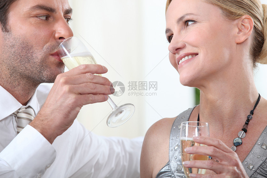 来两杯香槟领带男性眼睛头发微笑派对白色女性玻璃夫妻图片