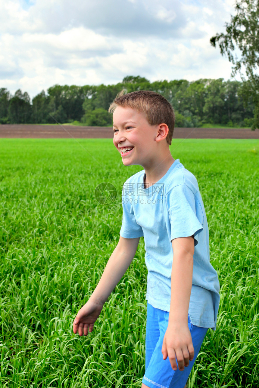 男孩在田野中孩子幸福童年太阳阳光自由衬衫天空乐趣草地图片