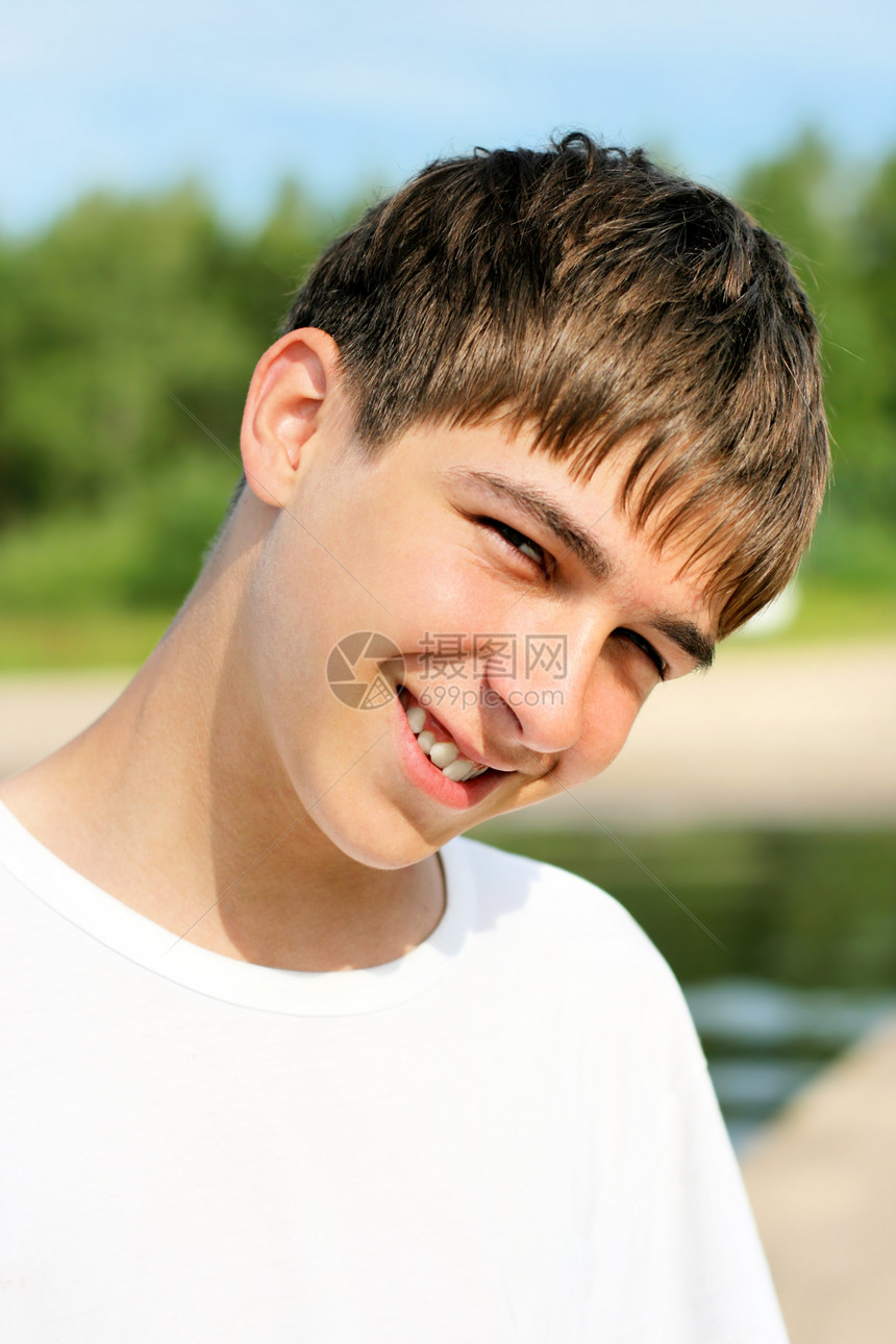 青少年在海滩上牙齿海岸线乐趣青年天气头发青春期幸福微笑天空图片