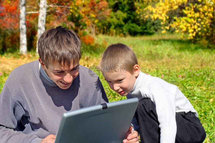 带笔记本的兄弟青年晴天孩子夫妻电脑兴趣检查小伙子树木游戏图片