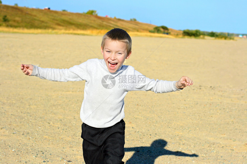 正在跑步的年轻男孩运动海滩喜悦欢乐男生青年乐趣支撑阳光快乐图片