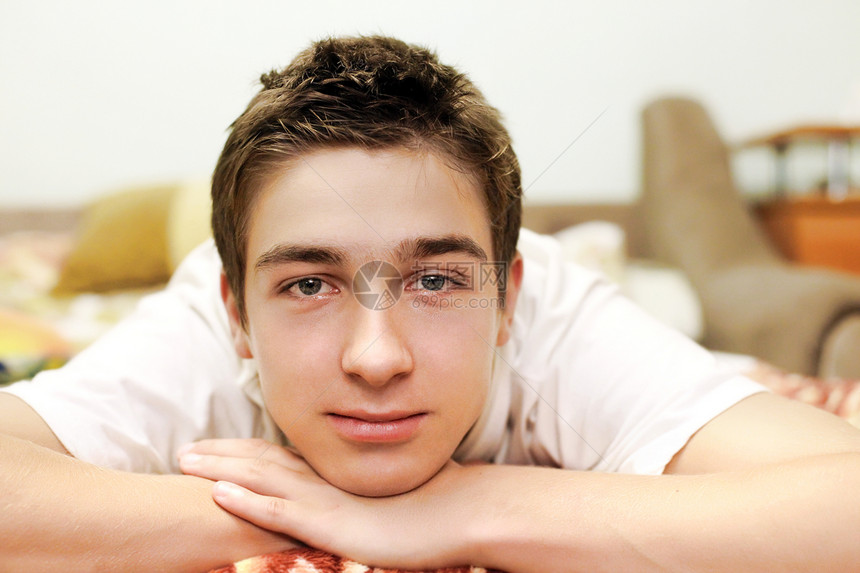 床上的年轻人幸福沙发隐藏棕色黑发眼睛房间男性男生微笑图片