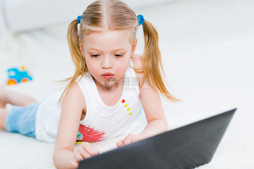 在笔记本电脑上工作的漂亮女孩裙子微笑学习幸福游戏瞳孔教育头发孩子女性图片