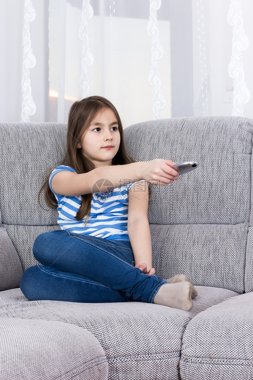可爱的小女孩 在沙发上看电视喜悦键盘技术头发文化微笑女孩婴儿按钮渠道图片