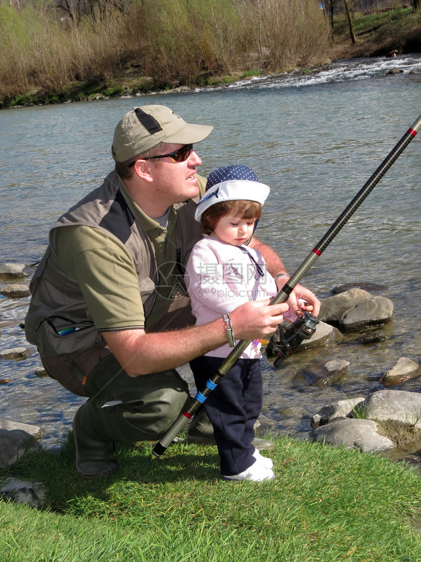 父亲和女儿在河上捕鱼蓝色爱好孩子微笑活动女孩家庭女性渔夫乐趣图片