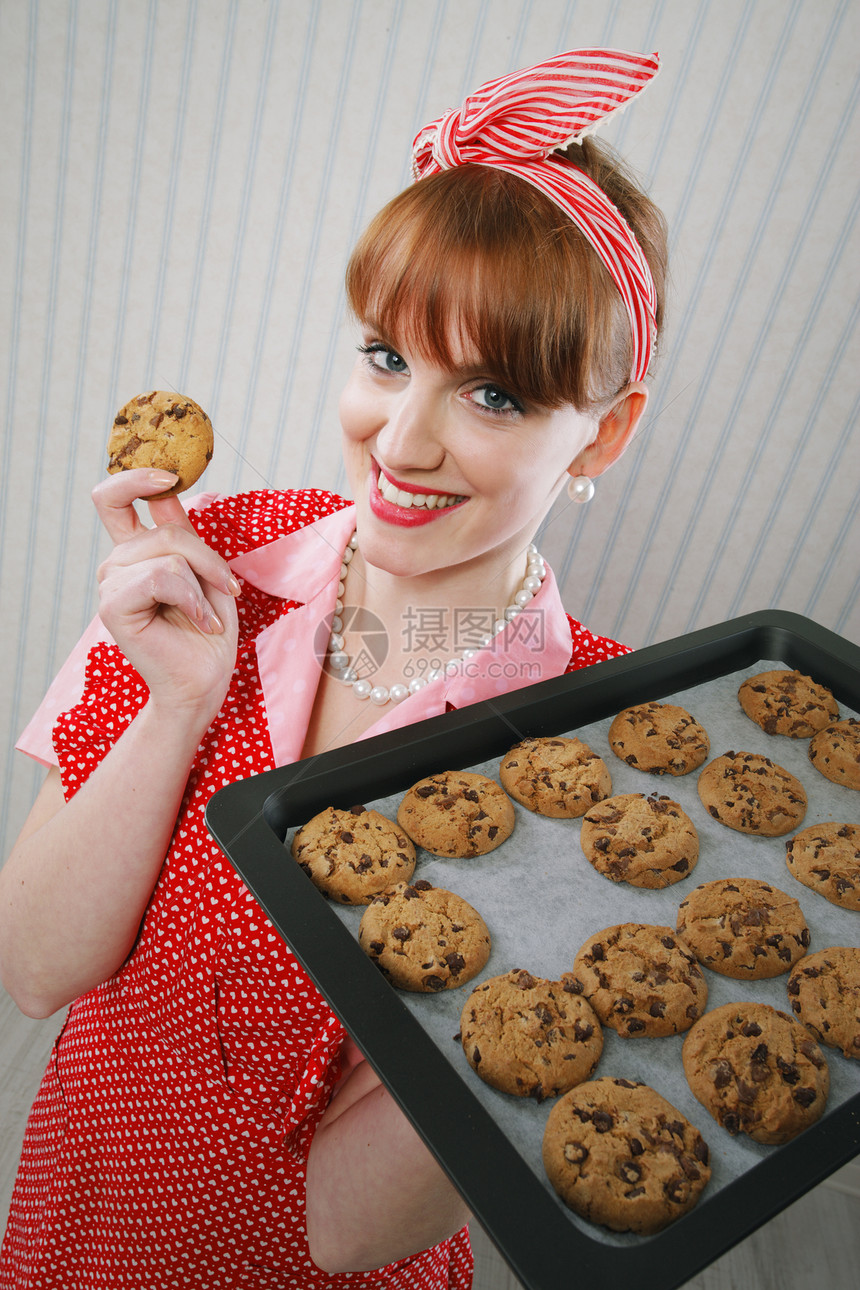 美丽的女人拿着热烤锅加巧克力饼干的辣妹图片
