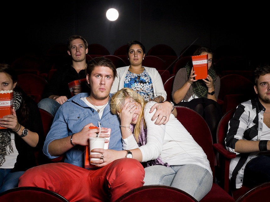 电影院的年轻夫妇放映机喜悦女性娱乐人群欢呼幸福背光群人电影图片