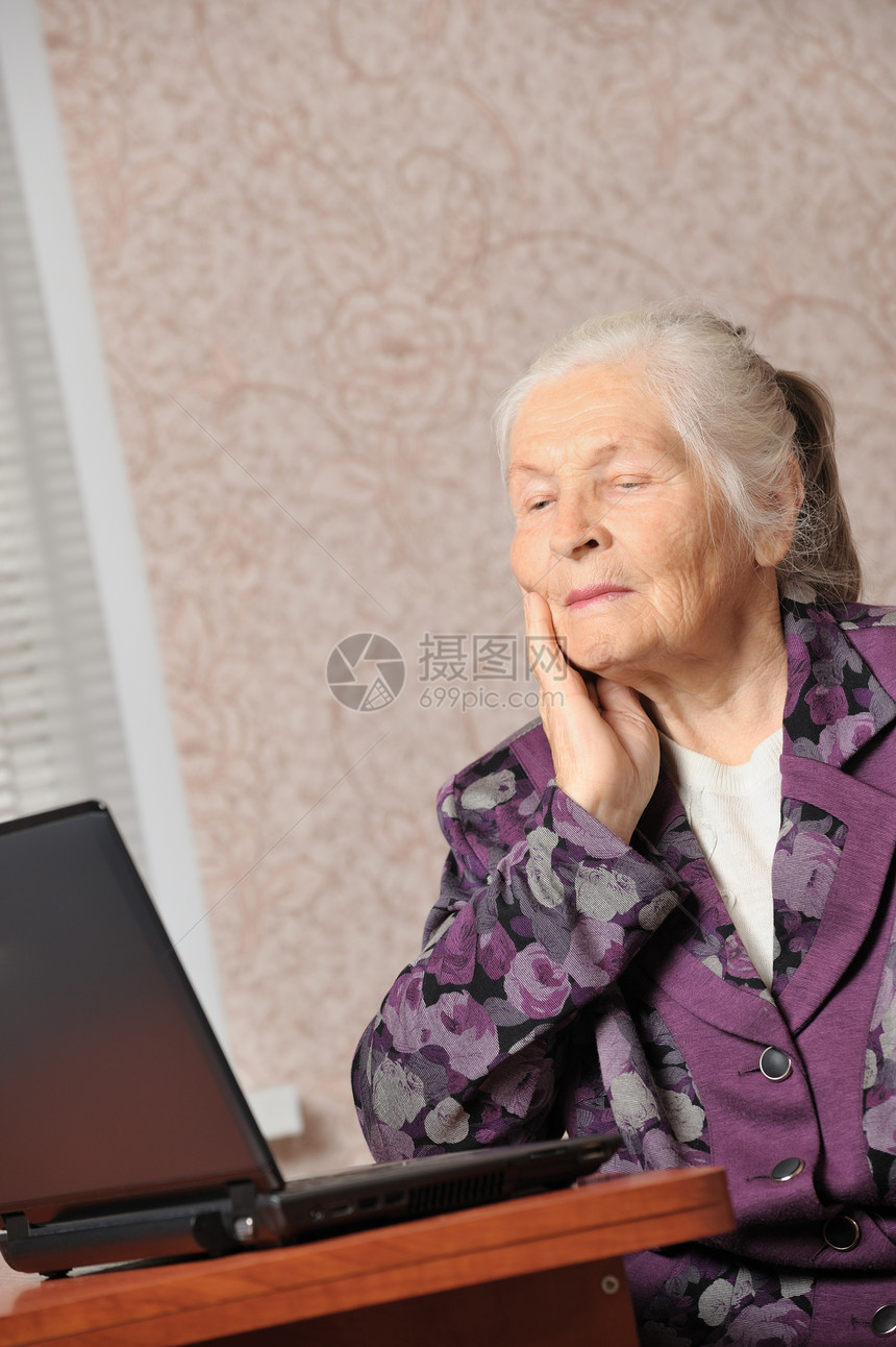在笔记本电脑前的老年妇女女性白色奶奶技术桌子商业祖母女士衣服微笑图片