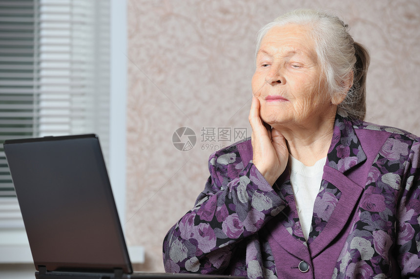 在笔记本电脑前的老年妇女成人女士灰色白色阅读智力起皱祖母桌子女性图片