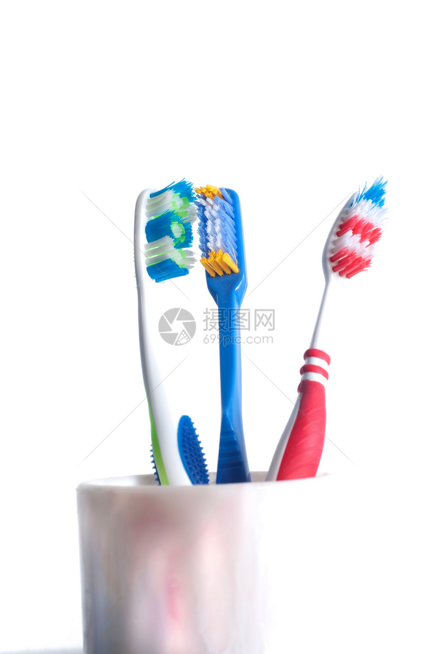 白玻璃杯中的彩色牙刷杯子绿色白色橙子牙科卫生夫妻洗手间药品牙齿图片