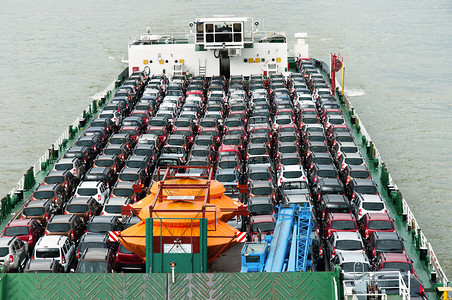 手拿着船汽车船载运大量汽车到市场销售背景