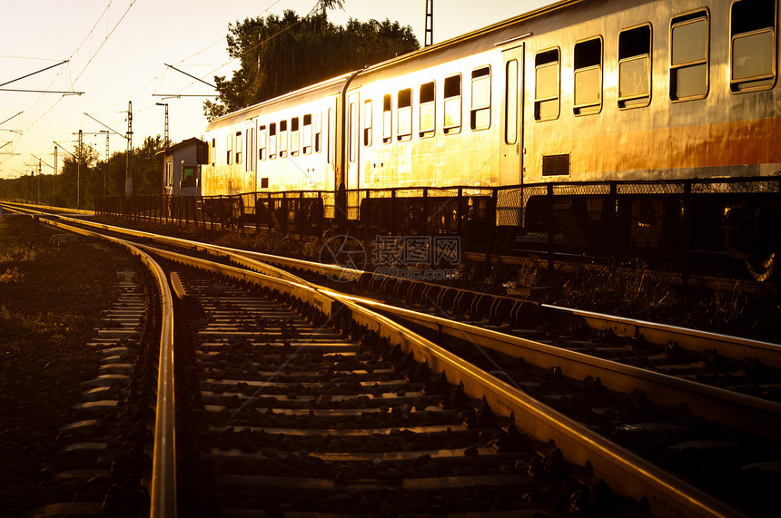 橙色日落时火车经过货物乘客太阳天空速度金属货运运输铁轨活力图片