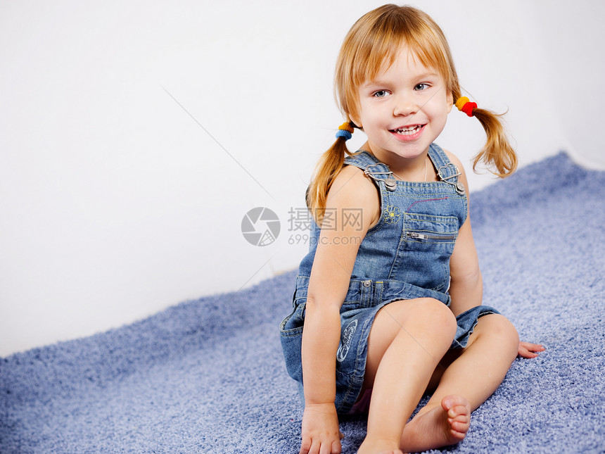 有趣可爱的小女孩发型孩子快乐微笑幸福房间鬼脸蓝色牛仔裤童年图片