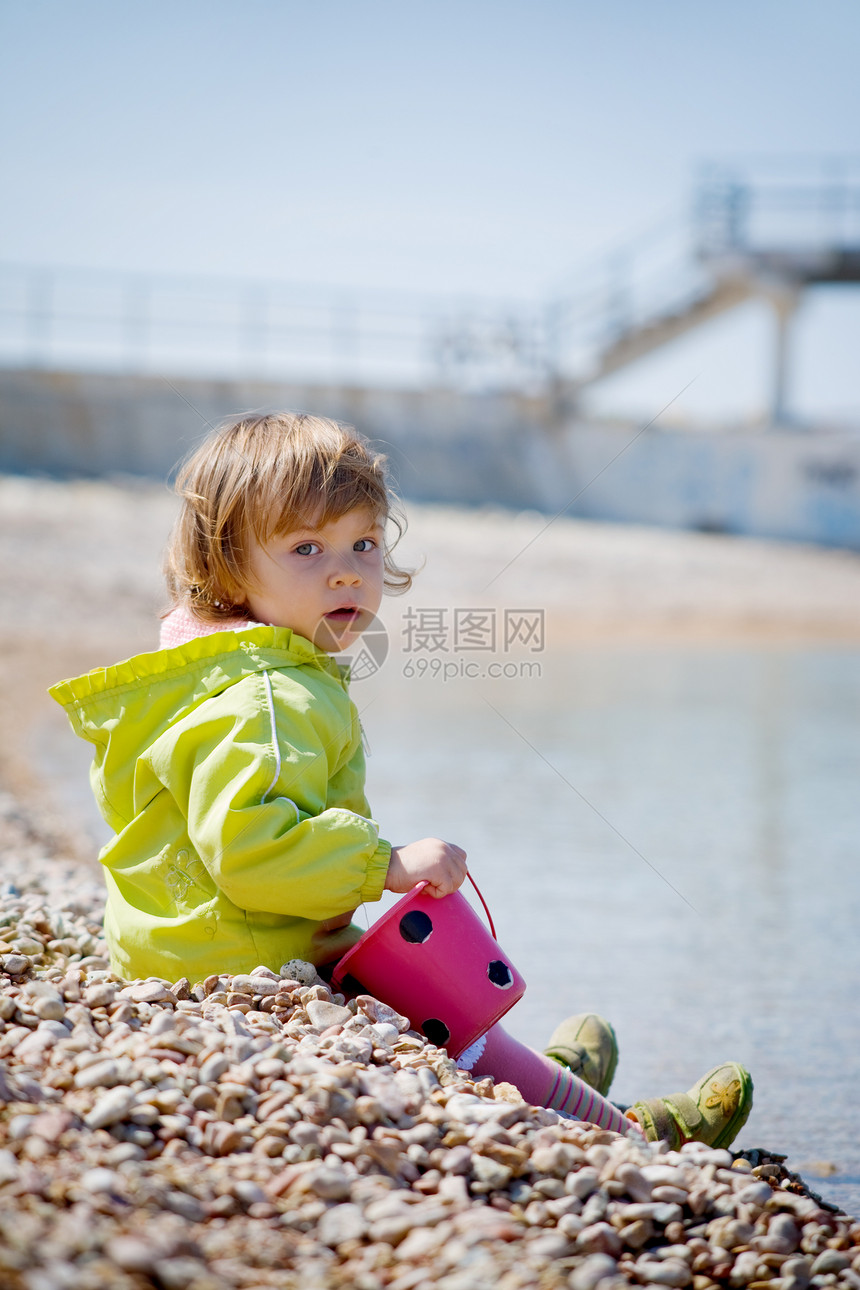 海滩上的孩子蓝色太阳石头阳光女性乐趣天空玩具女儿童年图片