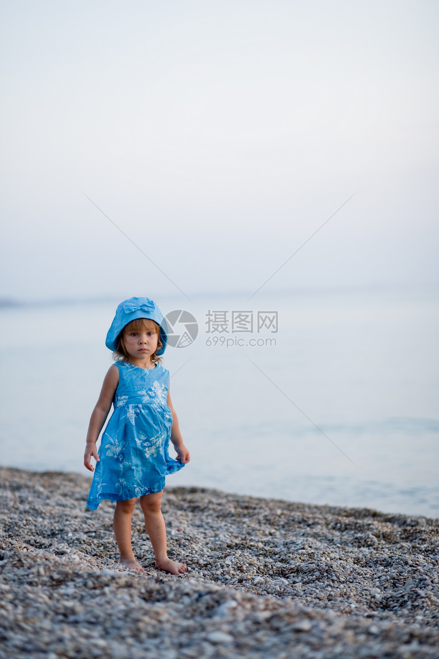 海滩上的小女孩海浪活动海洋衣服乐趣场景赤脚蓝色日落女性图片