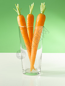 玻璃中的胡萝卜烹饪蔬菜绿色土壤橙子背景图片