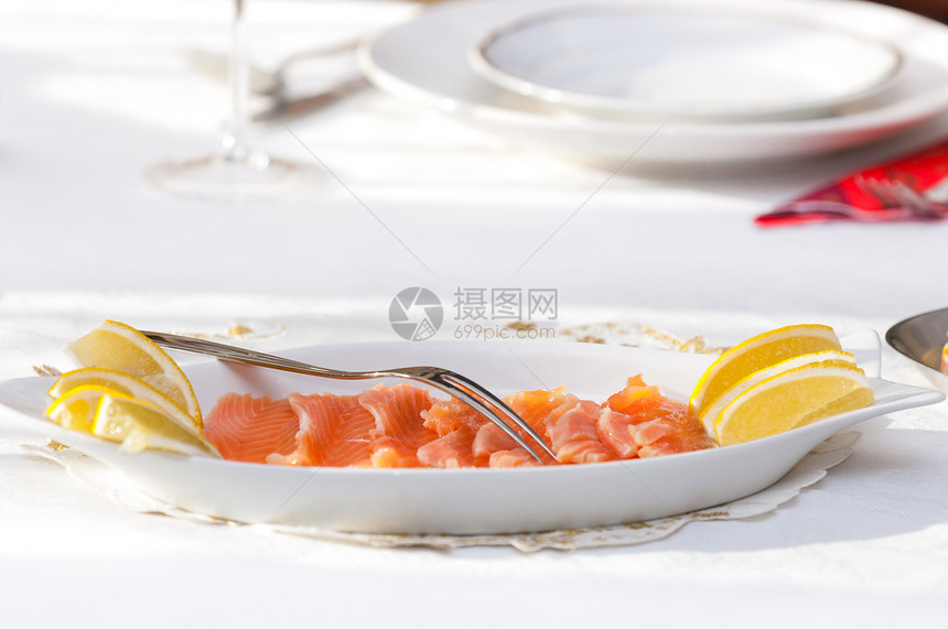 饭桌上的生鲑鱼用餐盘子红色桌子宏观食物午餐海鲜橙子牛扒图片