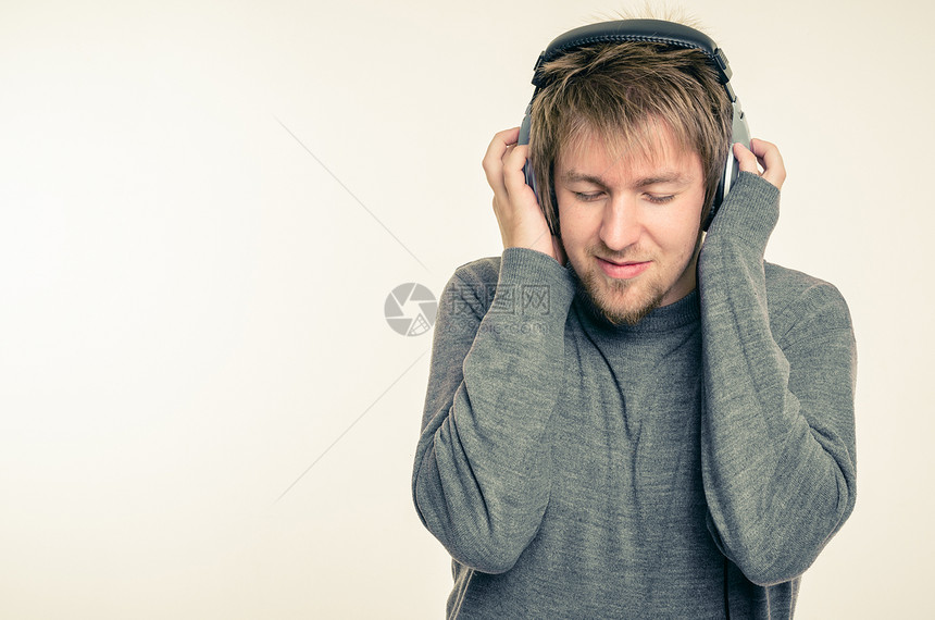 带耳机的年轻人喜悦耳朵立体声享受收音机白色微笑音乐记录岩石图片
