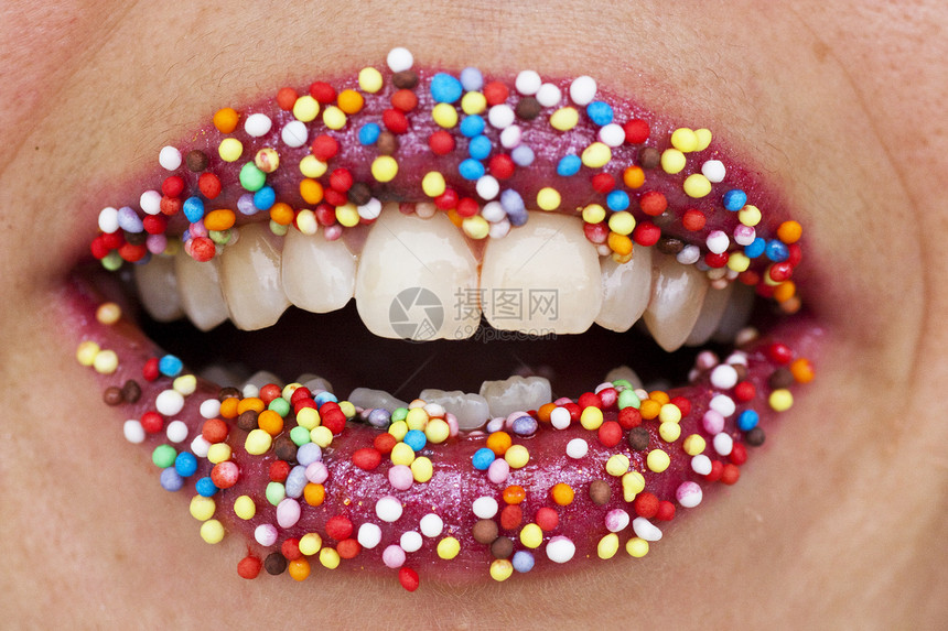 红色嘴唇上的彩色糖果宏观口红牙齿白色诱惑品味女性圆形女士胶合图片