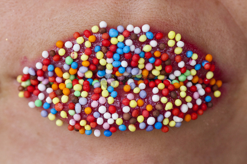 红色嘴唇上的彩色糖果胶合女孩女性女士口红圆形品味诱惑宏观图片