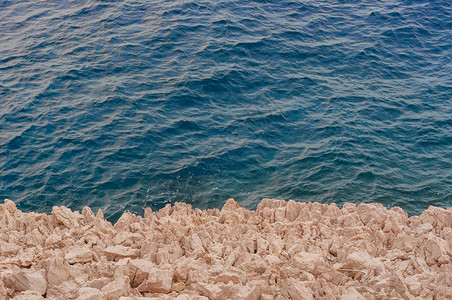 海岸的尖锐石块岩石地质学荒野灰色白色剃刀支撑危险悬崖蓝色背景图片
