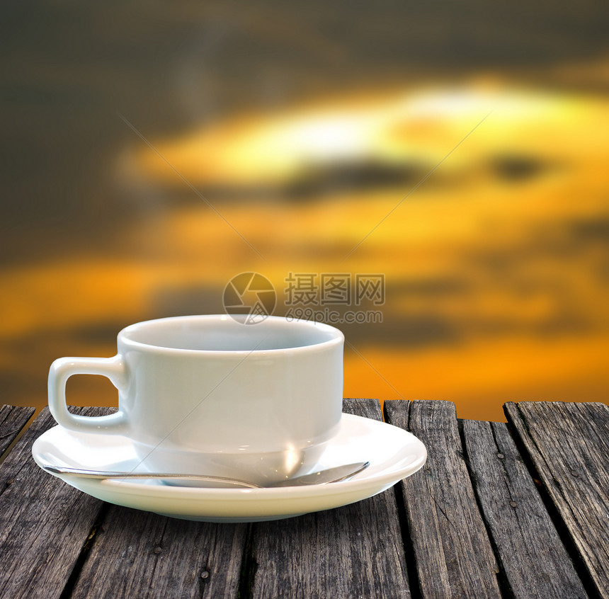 木制桌上的咖啡杯杯子旅行橙子假期热咖啡天空日落木头太阳白色图片