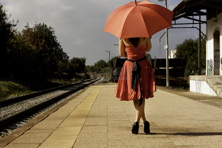 带雨伞的美女火车平台晴天美丽铁路曲目旅行裙子水池红色图片