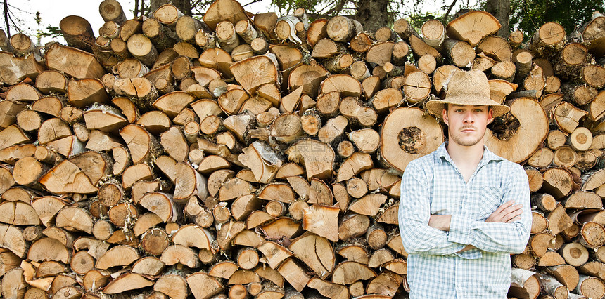 木头上戴草帽的木板匠刀刃木匠绳索男性日志工作稻草帽子林业工人图片